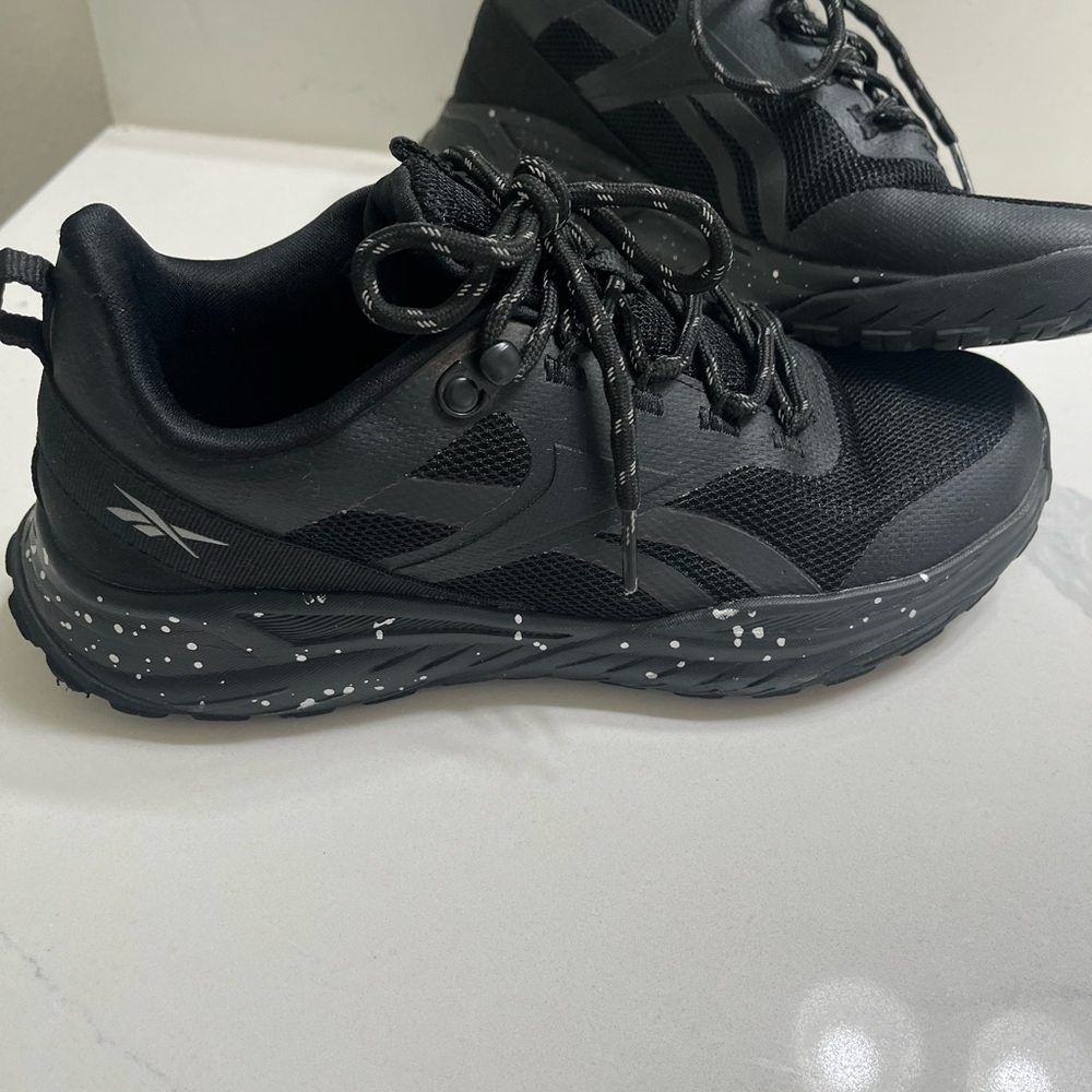 Reebok Women’s Lavante trail running shoe in black and white speckled detail.